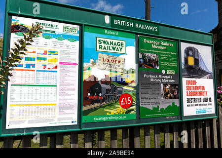 Inserzioni per viaggiare in treno. Anni Cinquanta anni sessanta Corfe Castle Stazione ferroviaria Dorset England Regno Unito Foto Stock