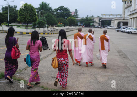 29.07.2013, Yangon, , Myanmar - tre giovani donne in costumi tradizionali a piedi dietro a tre monache buddiste nelle loro vesti. 0SL130729D001CARO.JPG [modello Foto Stock