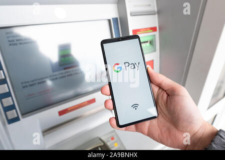 Wroclaw, Polonia - Nov 06, 2019: Uomo con smartphone con Google Pay logo. Google Pay è portafoglio elettronico sviluppato da Google. Foto Stock