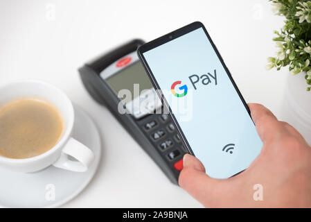 Wroclaw, Polonia - Nov 06, 2019: Uomo con smartphone con Google Pay logo. Google Pay è portafoglio elettronico sviluppato da Google. Foto Stock