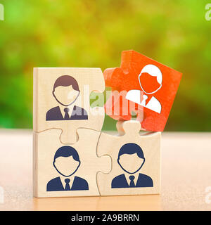 Puzzle in legno con l'immagine dei lavoratori. Il concetto di gestione del personale in azienda. Rigettando un dipendenti da un team. Retrocessione. Bad fun Foto Stock