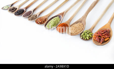 Spezie e cucchiai di legno contro uno sfondo bianco Foto Stock