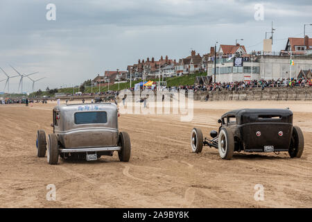 Due vintage hot rods linea fino alla "razza onde' evento, dove le automobili e motocicli drag race sulla spiaggia a Bridlington, East Yorkshire England Regno Unito Foto Stock