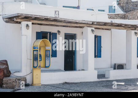 La città di Mykonos, Grecia - 23 Settembre 2019: Giallo telefono pubblico in una strada a Hora, conosciuta anche come la città di Mykonos, capitale della popolare islan greco Foto Stock