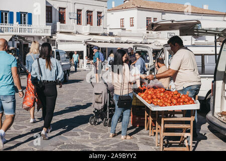 La città di Mykonos, Grecia - 23 Settembre 2019: Donna comprando i pomodori da un venditore ambulante in Hora, conosciuta anche come la città di Mykonos, capitale dell'isola e o Foto Stock