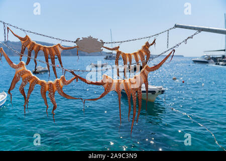 Quattro polpo appeso essiccazione nel sole sopra il mare blu tipico stile Medeterranean. Foto Stock