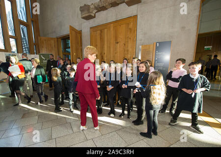 Edinburgh, Regno Unito. Il 14 novembre 2019. Nella foto: Nicola Storione MSP - Primo ministro di Scozia e il Leader del Partito nazionale scozzese (SNP) nella foto con la visita degli alunni della scuola al parlamento scozzese. Tutto il mondo è la nostra tappa - alunni non ha mai perso in Translanguaging. Questa performance multilingue si terrà nella Sala ustioni al Parlamento Scozzese (Edinburgh EH9 1SP) giovedì 14 novembre a 1:15p.m. Questo evento è solo su invito. Siamo particolarmente grati al signor Stuart McMillan MSP ufficio per la sua sponsorizzazione e supporto. Credito: Colin Fisher/Alamy Live News Foto Stock