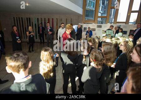 Edinburgh, Regno Unito. Il 14 novembre 2019. Nella foto: Nicola Storione MSP - Primo ministro di Scozia e il Leader del Partito nazionale scozzese (SNP) nella foto con la visita degli alunni della scuola al parlamento scozzese. Tutto il mondo è la nostra tappa - alunni non ha mai perso in Translanguaging. Questa performance multilingue si terrà nella Sala ustioni al Parlamento Scozzese (Edinburgh EH9 1SP) giovedì 14 novembre a 1:15p.m. Questo evento è solo su invito. Siamo particolarmente grati al signor Stuart McMillan MSP ufficio per la sua sponsorizzazione e supporto. Credito: Colin Fisher/Alamy Live News Foto Stock