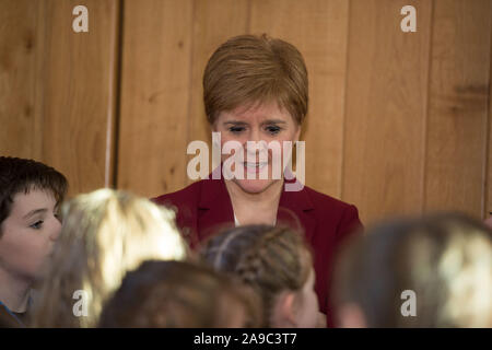 Edinburgh, Regno Unito. Il 14 novembre 2019. Nella foto: Nicola Storione MSP - Primo ministro di Scozia e il Leader del Partito nazionale scozzese (SNP) nella foto con la visita degli alunni della scuola al parlamento scozzese. Tutto il mondo è la nostra tappa - alunni non ha mai perso in Translanguaging. Questa performance multilingue si terrà nella Sala ustioni al Parlamento Scozzese (Edinburgh EH9 1SP) giovedì 14 novembre a 1:15p.m. Questo evento è solo su invito. Siamo particolarmente grati al signor Stuart McMillan MSP ufficio per la sua sponsorizzazione e supporto. Credito: Colin Fisher/Alamy Live News Foto Stock