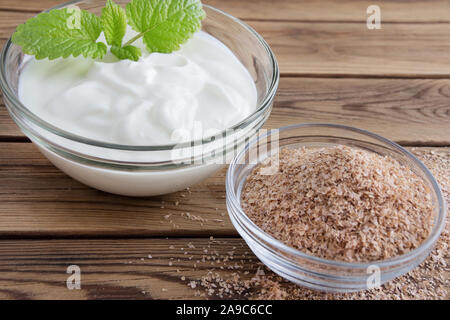 Yogurt e crusca di frumento su sfondo di legno Foto Stock