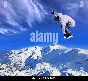 Sciatore Snowboarder jumping attraverso aria con cielo blu in background Foto Stock