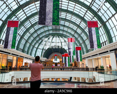 Dubai / Emirati Arabi Uniti - 10 Novembre 2019: decorazioni per il cittadino UAE giorno nel centro commerciale Mall of the Emirates. Emirati Arabi Uniti bandiere nazionali decorazione. Giorno di indipendenza. L uomo è tak Foto Stock