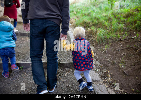 Padre e figlio salgono insieme sulla collina di Calton, tenendo le mani Foto Stock