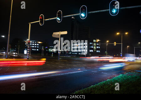 Intersezione di notte con semafori e traffico offuscata dal movimento in Arnhem, Paesi Bassi Foto Stock