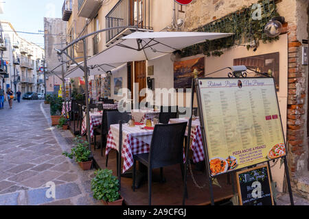 Cena all'aperto a Cefalú. Tavoli disposti in tempo per il commercio serale. Foto Stock