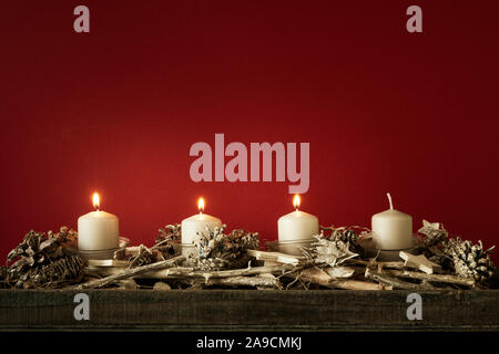 Il tempo di Avvento tre candele accese con sfondo rosso per i tuoi contenuti Foto Stock