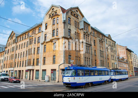 Era sovietica in Riga, Lettonia. Gli edifici di vecchia costruzione con scritti in cirillico, architettura sovietica con il vecchio tram in Riga Foto Stock