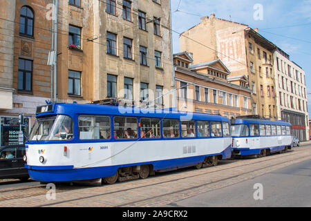 Era sovietica in Riga, Lettonia. Gli edifici di vecchia costruzione con scritti in cirillico, architettura sovietica con il vecchio tram in Riga Foto Stock