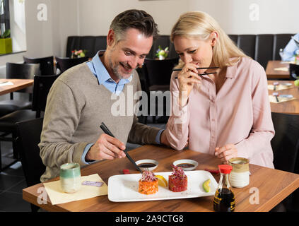 Giovane, sorridente, mangiare sushi, metà ritratto, Foto Stock