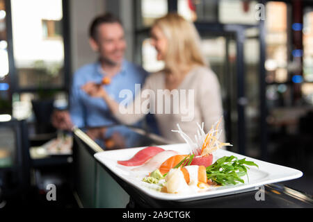 Giovane, sorridente, mangiare sushi, metà ritratto, Foto Stock