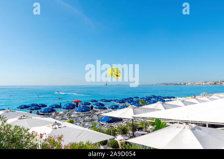Un felice faccina paracadute parasailer decolla da un resort sulla spiaggia presso il lungomare sulla Riviera Francese a Nizza, in Francia. Foto Stock