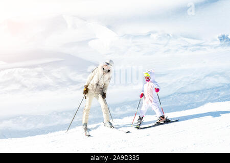 I giovani adulti bella madre sportivo avendo divertimento sugli sci con kid figlia sulla montagna sci delle Alpi Winter Resort. Slim mom in moda di lusso sciatore suit Foto Stock