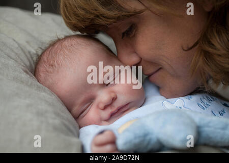 Cuddling madre con bambino, strofinando il naso sul baby la guancia Foto Stock