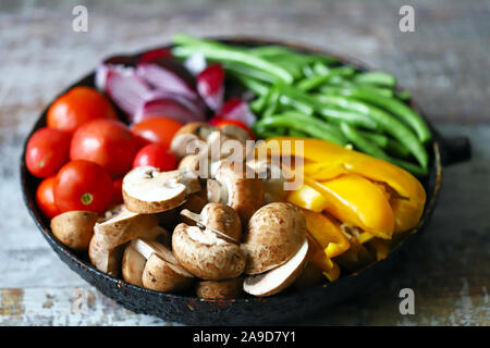 Verdure colorate in una padella prima di cuocere. Ricetta vegana. Cibo sano e luminoso. Foto Stock