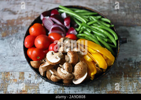 Verdure colorate in una padella prima di cuocere. Ricetta vegana. Cibo sano e luminoso. Foto Stock
