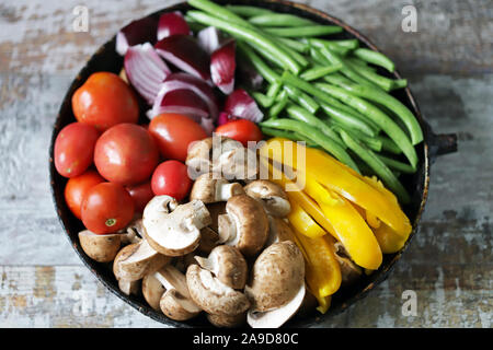 Verdure colorate in una padella prima di cuocere. Ricetta vegana. Cibo sano e luminoso. Foto Stock