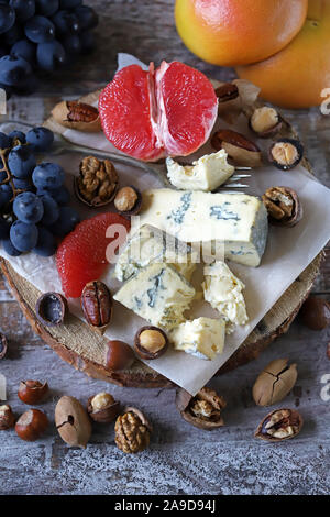 Set di formaggio con i dadi e i frutti. Dieta cheto. Cheto snack. Cheto impostare il fuoco selettivo. Macro. Foto Stock