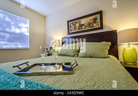 Un vassoio con champagne flauti siede su un letto in una camera da letto a Boschi di autunno appartamenti, situato sulla strada Foreman nel Mobile, Alabama. Foto Stock