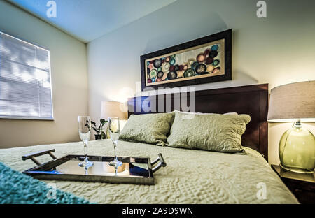 Un vassoio con champagne flauti siede su un letto in una camera da letto a Boschi di autunno appartamenti, situato sulla strada Foreman nel Mobile, Alabama. Foto Stock