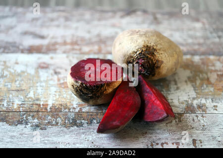 Bietole su una superficie di legno. Barbabietole rosse insieme e affettato. Messa a fuoco selettiva. Macro. Copia dello spazio. Foto Stock