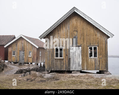 La Svezia, Bohus, West Coast, Kattegat, vecchi pescatori di cabine sulla costa vicino Hamburgsund, mare di nebbia Foto Stock