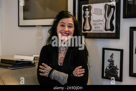 Berlino, Germania. Xiv Nov, 2019. Duden netti, manager del negozio di un tatuaggio studio in Prenzlauer Berg, sorge nel foyer del studio. Anche lei indossa un lutto tattoo, un disegno del suo fine tomcat. Credito: Paolo Zinken/dpa/Alamy Live News Foto Stock