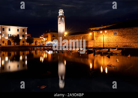 Barche in città vecchia porto di Lazise al crepuscolo. La città è una popolare destinazione per una vacanza in Garda Lake District. Foto Stock