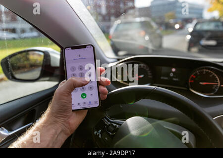 Uomo di comporre un numero sul suo telefono cellulare in auto, dettaglio immagine simbolica, telefono cellulare al volante, Foto Stock