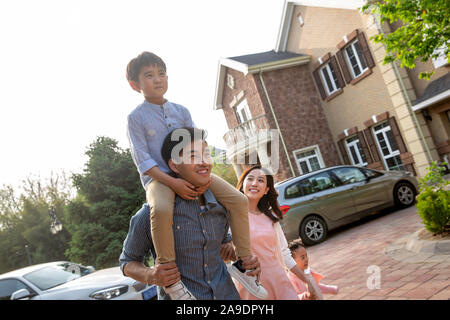 La famiglia felice la riproduzione al di fuori della villa Foto Stock