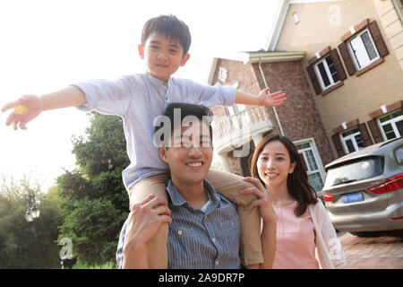 La famiglia felice la riproduzione al di fuori della villa Foto Stock