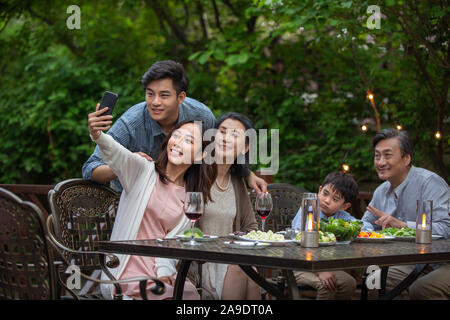 La famiglia felice la cena in giardino Foto Stock