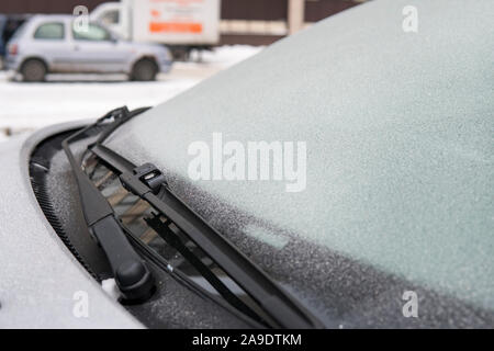 Fiocchi di neve ghiacciata su frosty auto in freddo. tergicristallo su un auto. auto bidello si è bloccato al vetro della vettura a bassa temperatura. Problemi con auto in Foto Stock