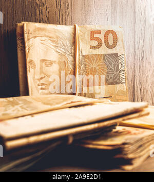 Valuta brasiliana. Foto di un gruppo di 50 reais note su mobili in legno. Foto Stock