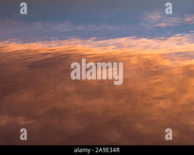 Il mirroring del sorgere del sole in superficie dell'acqua Foto Stock