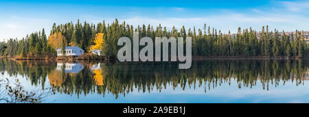 Canada, panorama di un lago di montagna nella foresta durante l'estate indiana, la riflessione degli alberi in acqua Foto Stock