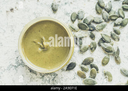 Burro di semi in vasi di vetro con ingredienti. In casa di materie organiche semi di zucca pasta su una tavola. Vista dall'alto. Foto Stock