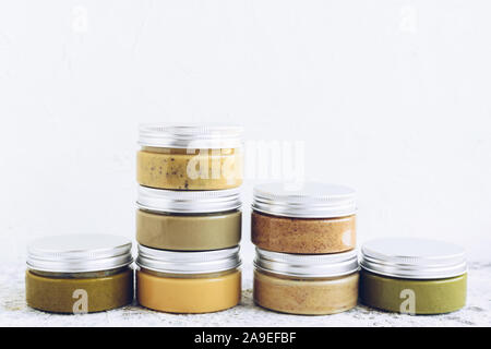 Noci e semi burro in vasetti di vetro. In casa di materie organiche, arachidi, mandorle hazlenut, anacardi, pistacchio, noci macadamia e pasta di semi di girasole e zucca Foto Stock