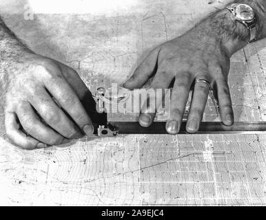 1957 - Utilizzando un giunto graver con un acciaio bordo dritto per tracciare una strada sulla piastra di coltura di una mappa topografica. Foto Stock