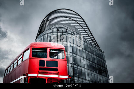 Bus rosso davanti al palazzo di vetro Foto Stock