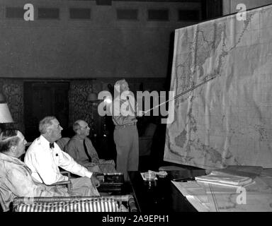 Admiral Chester W. Nimitz, USN, comandante in capo della flotta del Pacifico e Oceano Pacifico aree (in piedi) conferisce con (da sinistra a destra) General Douglas MacArthur, Presidente Franklin D. Roosevelt e l'ammiraglio William D. Leahy concernente la futura si muove nella guerra contro il Giappone, durante la visita del Presidente alle Hawaii, 26 luglio-10 agosto 1944 Foto Stock